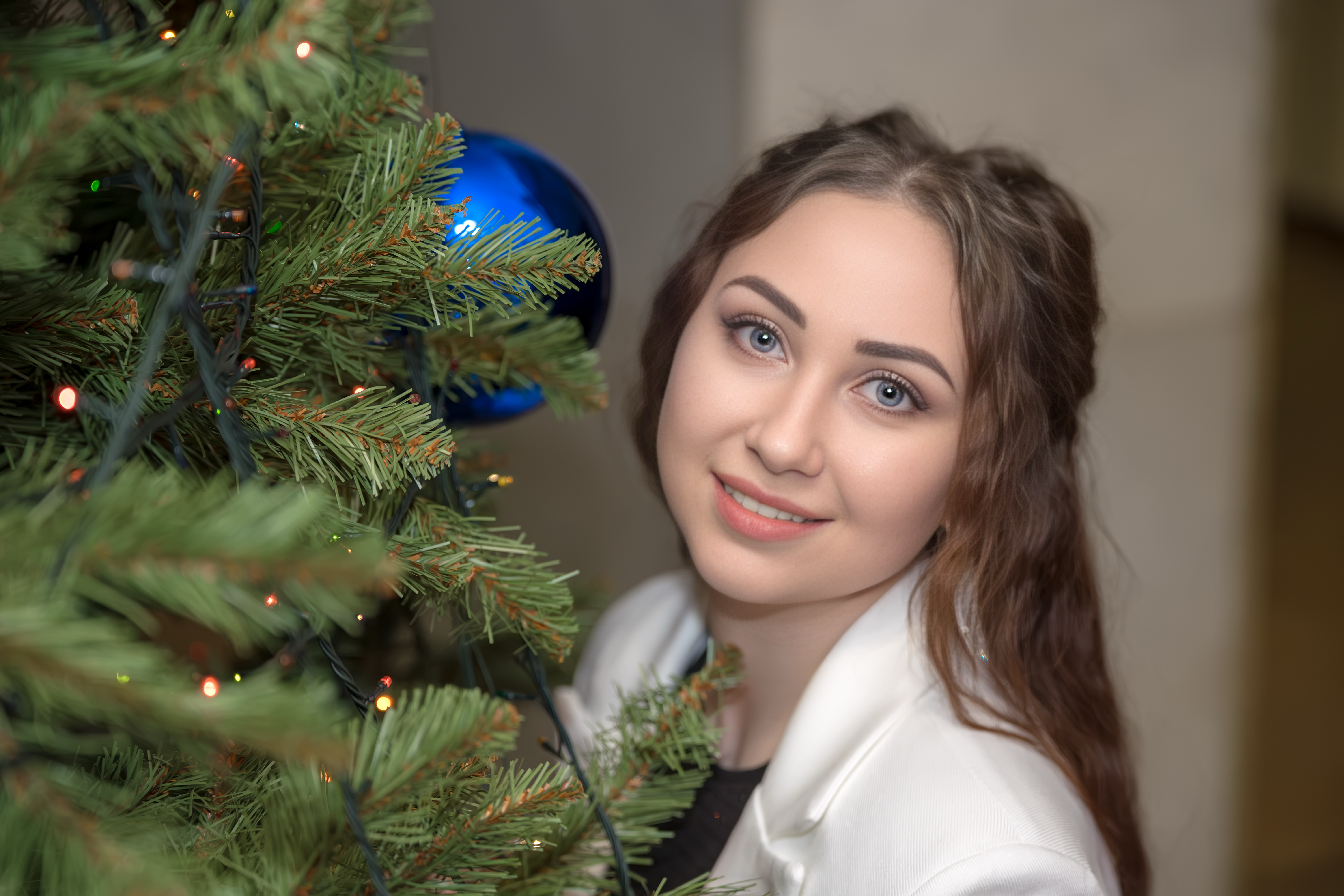 Ведущая рядом с праздничной елкой